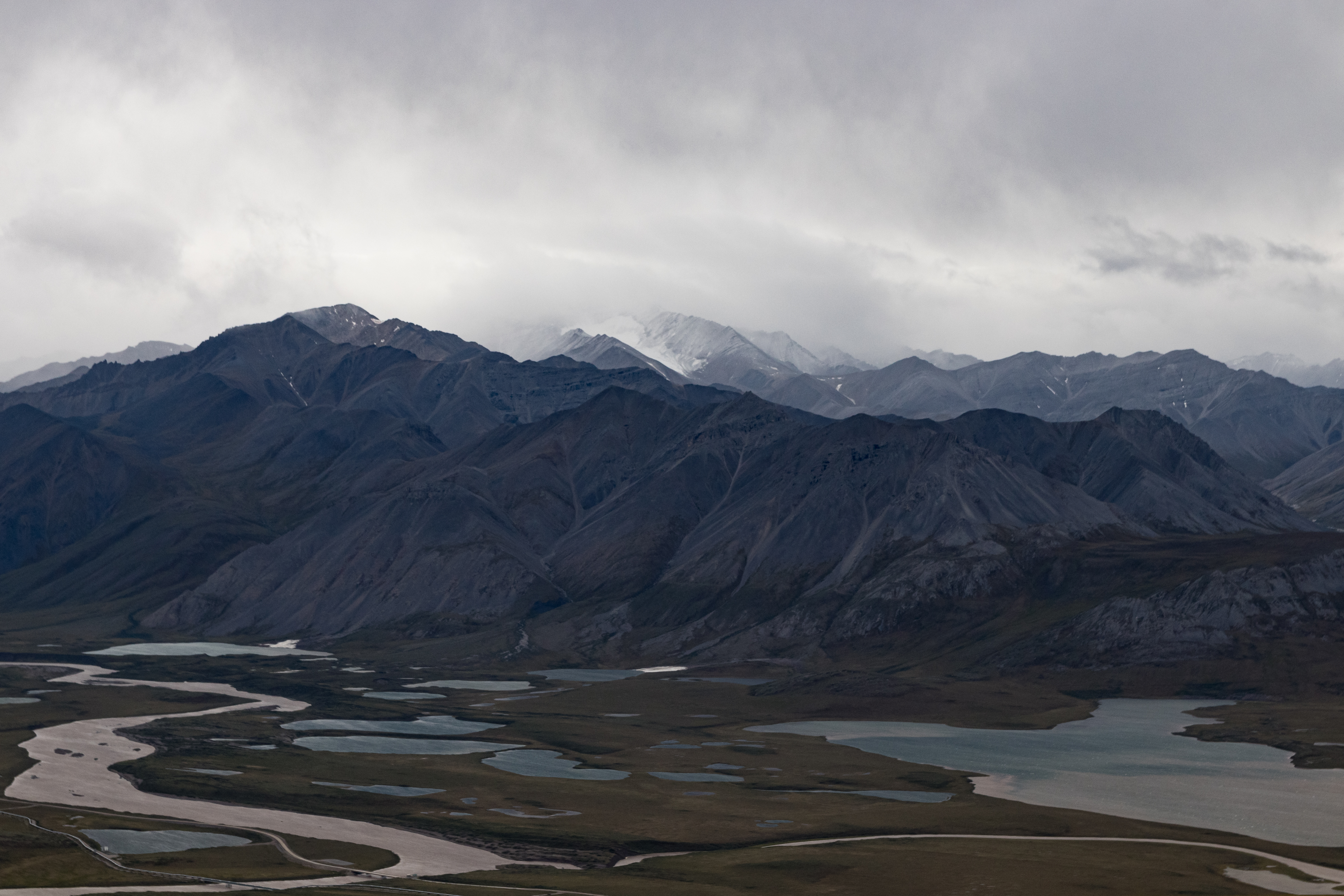 View of a valley with streams, and mountains behind